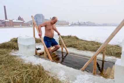 Крещенские купания в Санкт-Петербурге. Мужчина окунается в прорубь в Неве.