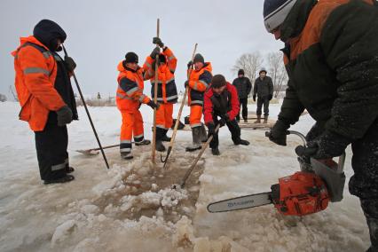 Подготовка к крещенским купаниям в Уфе. Рабочие пробивают лед на месте купели в реке.