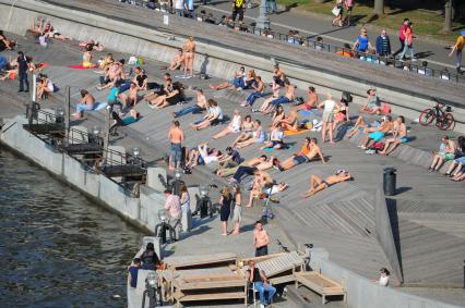 Москва. Девушки загорают на Пушкинской набережной.