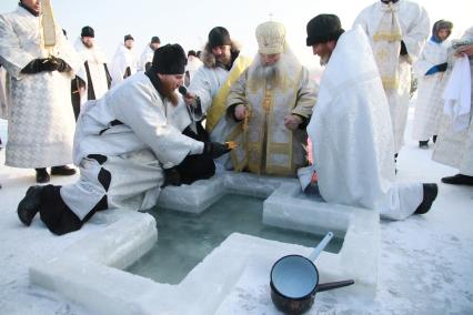 Крещенские купания в Барнауле. Священнослужитель освящает прорубь.