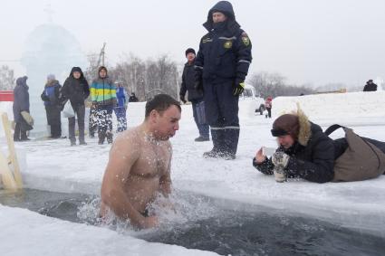 Крещенские купания в Иркутске. Мужчина окунается в проруби.