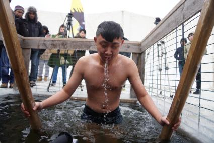 Крещенские купания в Екатеринбурге. Студент горного университета из Китая окунается в проруби в Малоистокском пруду.