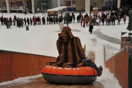 Москва. Женщина катается на ледяной горке в парке искусств Музеон.