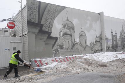 Москва.  Дворник чистит дорогу от снега.