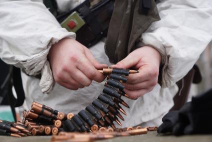 Свердловская область. Адуйский военный полигон. Военнослужащий мотострелковых войск заряжает пулеметную ленту в ходе проверки войск на способность слаженной работы между подразделениями.