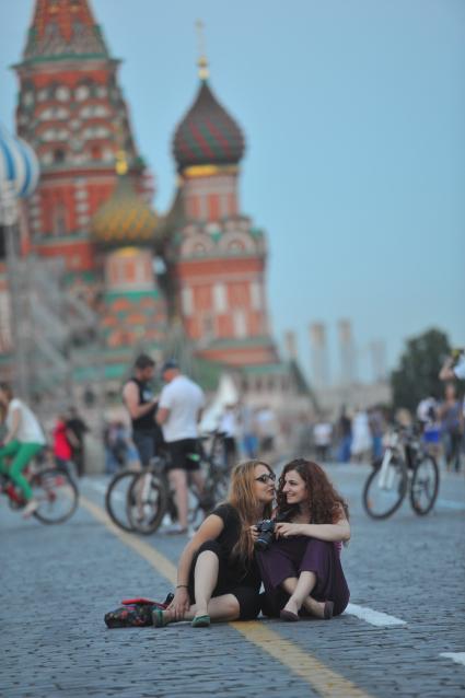 Москва. Девушки с фотокамерой сидят на Красной площади.