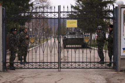 Крымский кризис. Военные без опознавательных знаков заблокировали военную часть А-2320 в селе Перевальное, которая отказалась сдавать оружие. Украинские военные за воротами.