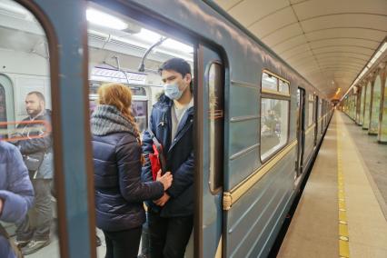 Санкт-Петербург. Молодые люди в медицинских масках в вагоне поезда.