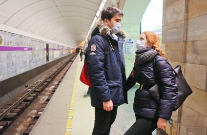 Санкт-Петербург. Молодые люди в медицинских масках на станции метро.