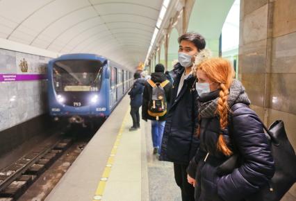 Санкт-Петербург. Молодые люди в медицинских масках на станции метро.