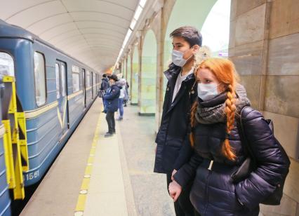 Санкт-Петербург. Молодые люди в медицинских масках на станции метро.