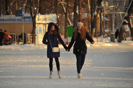 Москва.  Девушки катаются на коньках  в парке Сокольники.