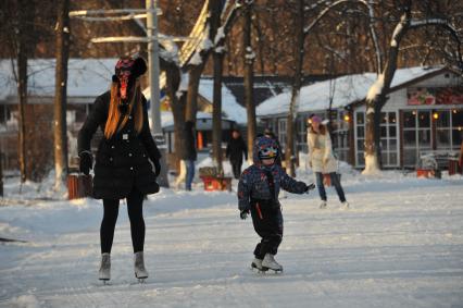 Москва.  Люди катаются на коньках в парке Сокольники.