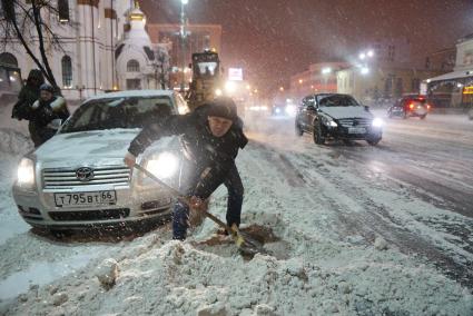 Екатеринбург. Мужчина очищает от снега автомобиль.