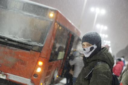 Екатеринбург. Молодой человек в маске с нарисованным черепом стоит на автобусной остановке.