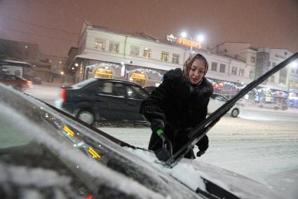 Екатеринбург. Женщина очищает от снега автомобиль.