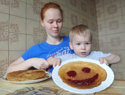 Москва. Девушка с ребенком демонстрируют блин со смайликом из варенья.