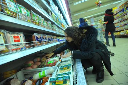 Москва. Покупательница у витрины с мясной продукцией в универсаме.