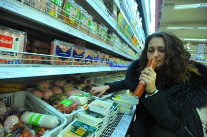 Москва.  Покупательница  у витрины с мясной продукцией в универсаме.