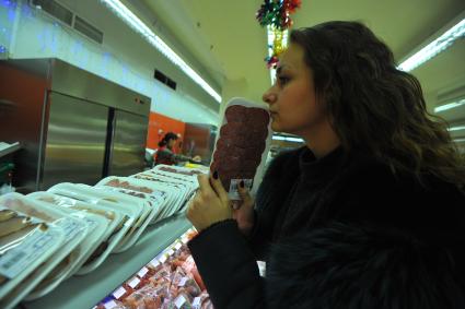 Москва. Покупательница у витрины с мясной продукцией в универсаме.