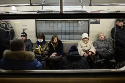 Эпидемия свиного гриппа в Москве. Женщина в медицинской маске едет в вагоне метро.