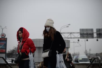 Эпидемия свиного гриппа в Москве. Девушка в медицинской маске идет по улице.