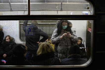 Эпидемия свиного гриппа в Москве. Девушка в медицинской маске едет в вагоне метро.