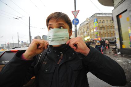 Эпидемия свиного гриппа в Москве. Мужчина в медицинской маске идет по улице.