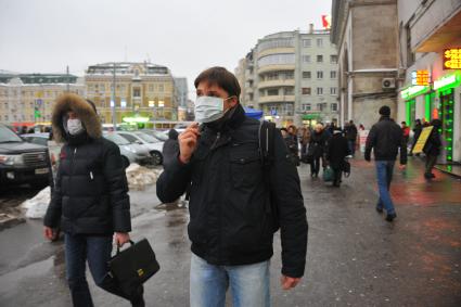 Эпидемия свиного гриппа в Москве. Мужчина в медицинской маске идет по улице.