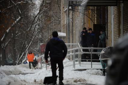 Москва.  Дворники чистят снег на одной из улиц города.