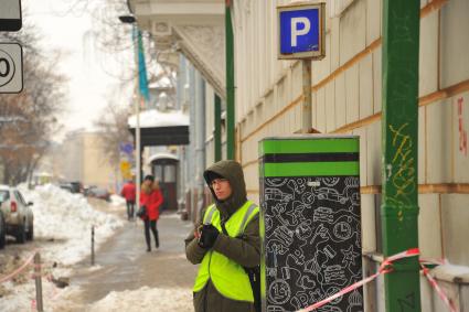 Москва.  Работник парковки на одной из улиц города.