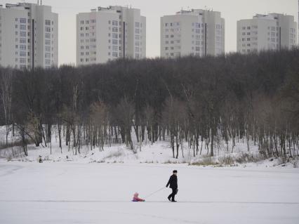 Тула. Мужчина везет на санках ребенка.