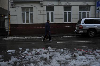 Москва.  Женщина идет по одной из улиц города.