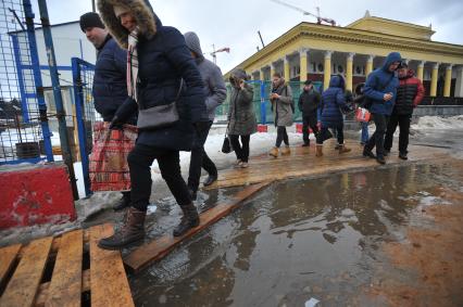 Москва.    Прохожие обходят лужи у станции метро `Динамо`.