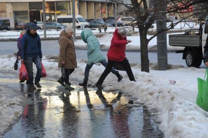 Москва.   Люди обходят лужу  на тротуаре.