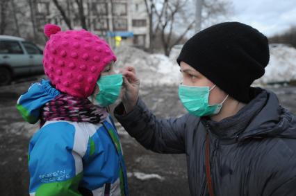 Москва. Женщина с ребенком в медицинских масках во время прогулки.