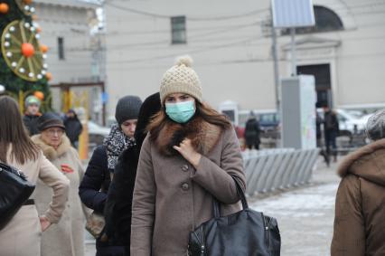 Москва.  Девушка в медицинской маске на одной из улиц города.