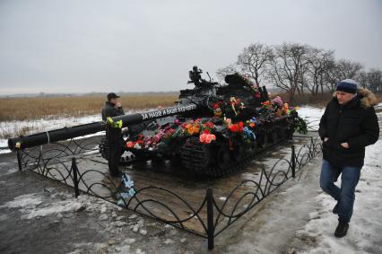 Украина. Луганская область. Село Хрящеватое под Луганском. Цветы и надпись на сгоревшем танке `За наше и ваше будущее`.