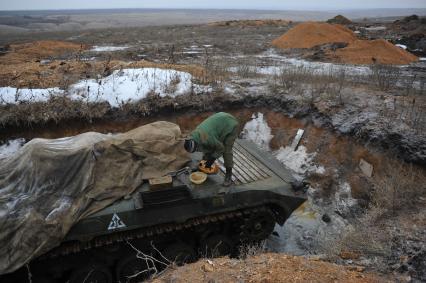 Украина. Донецкая область. Боевые позиции ополченцев ДНР. Боец отряда `Викинг`стоит на БМП.