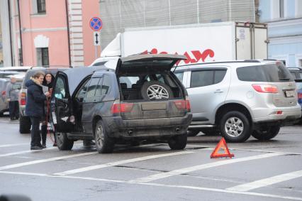 Москва.   Мужчина ремонтирует автомобиль.