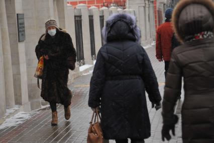 Москва.  Девушка в медицинской маске на одной из улиц города.