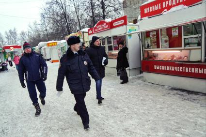 Екатеринбург. Полицейский и сотрудники комитета по товарному рынку во время совместного рейда администрации Екатеринбурга и полиции по пресечению незаконной торговли.