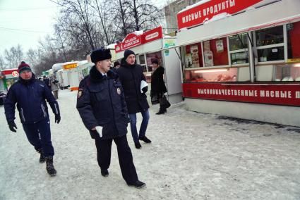 Екатеринбург. Полицейский и сотрудники комитета по товарному рынку во время совместного рейда администрации Екатеринбурга и полиции по пресечению незаконной торговли.