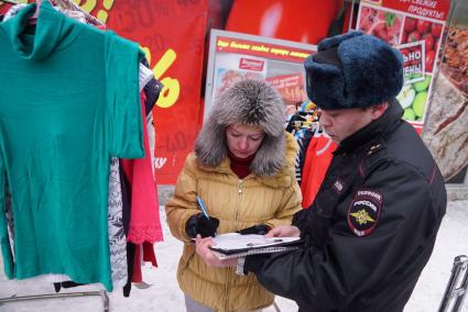 Екатеринбург. Полицейский составляет акт о нарушении правил торговли в отношении продавщицы во время совместного рейда администрации Екатеринбурга и полиции по пресечению незаконной торговли.