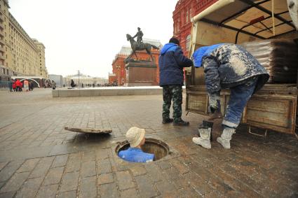 Москва. Бригада слесарей аварийно-восстановительных работ проводят технический осмотр канализационной сети на площади Революции.