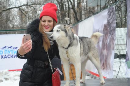 Москва.   Девушка делает селфи с хаски в парке Сокольники.