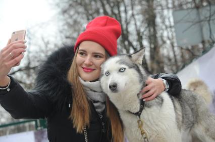 Москва.   Девушка делает селфи с хаски в парке Сокольники.