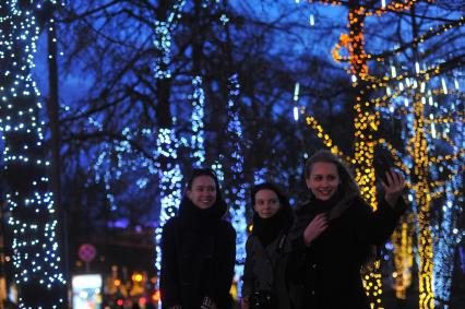 Москва. Девушки делают селфи на фоне вечерней подсветки.