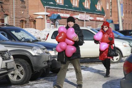 День Святого Валентина в Барнауле. Люди с воздушными шариками `сердечками` идут по улице.