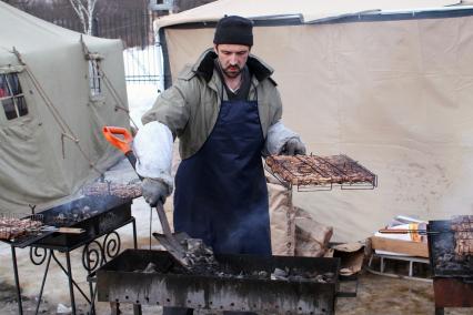 Масленица в Мураново. Повар готовит шашлык на мангале.